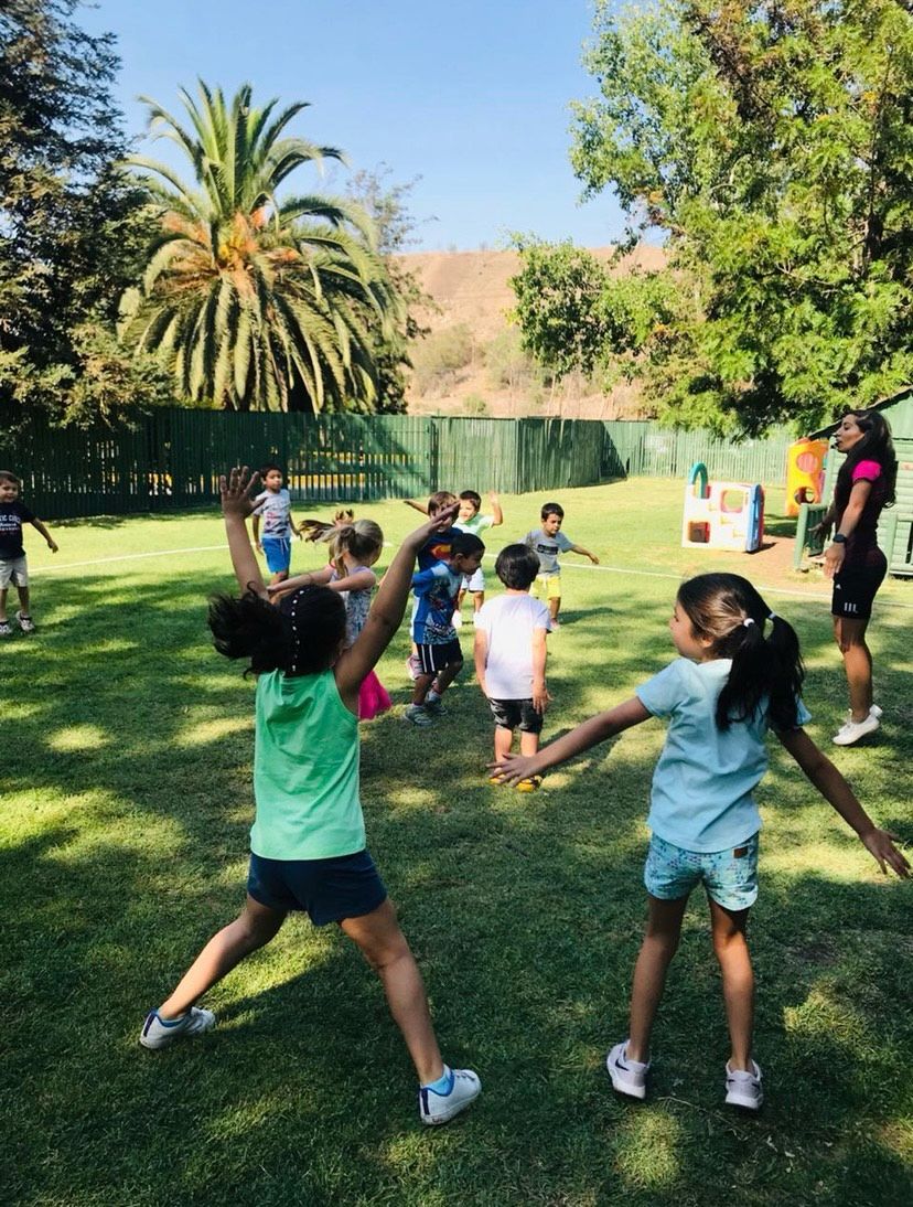 Niños jugando al aire libre con palmera de fondo