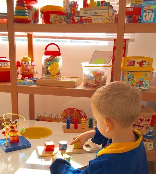 Niño jugando con encajables y materiales pedagógicos